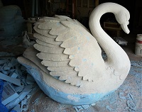 Swans carved in blue styrofoam covered with skin of plaster and fiberglass